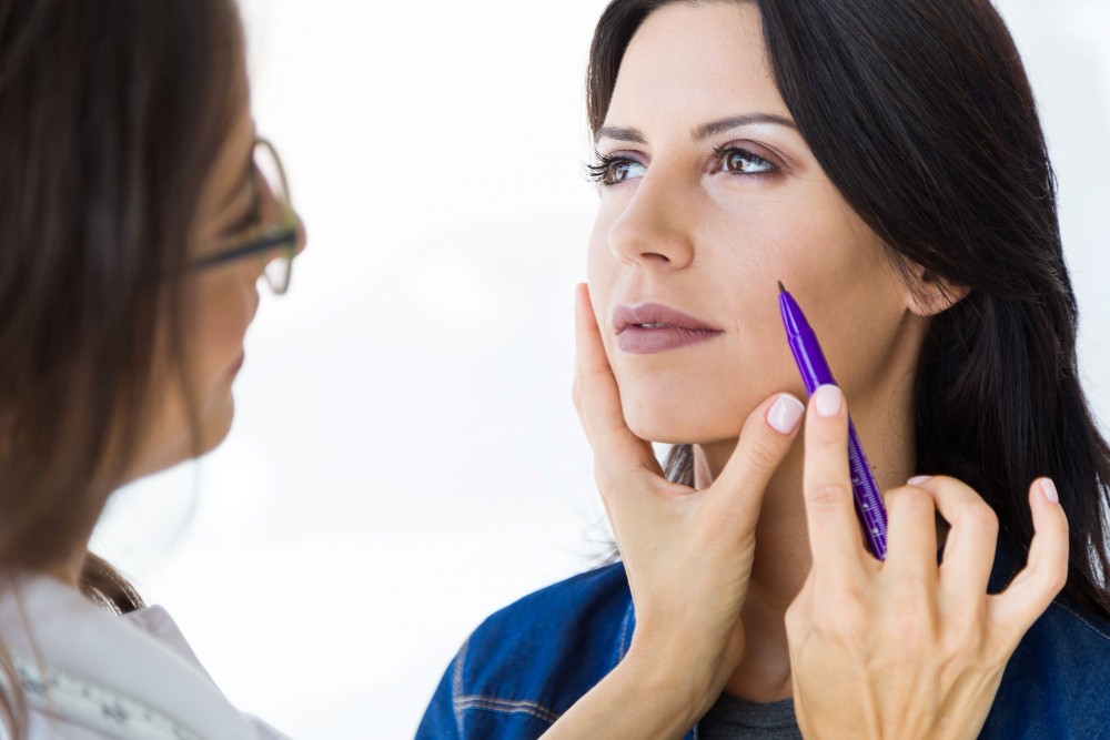 Paciente de Infinity Clinic siendo preparada por staff de la clínica para comenzar su tratamiento de relleno facial